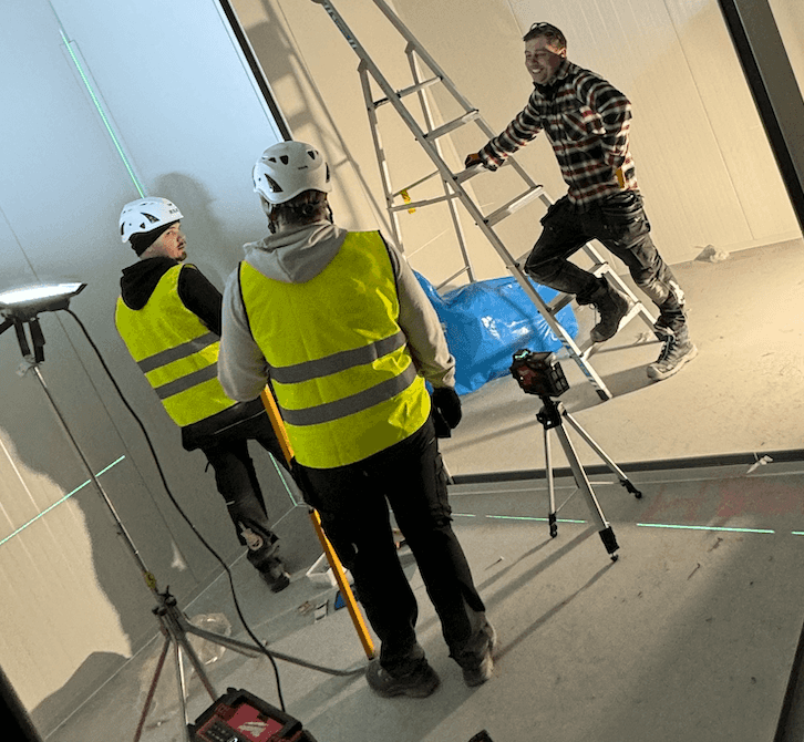 Montageteam arbetar med laser i kylrum